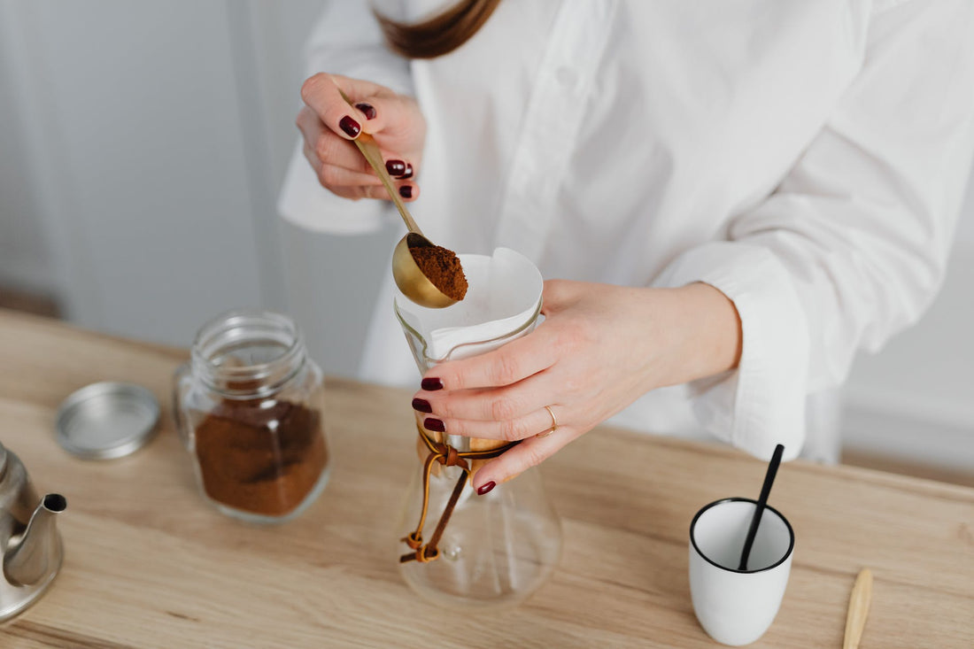 Barista measuring coffee grounds and water using a digital scale.